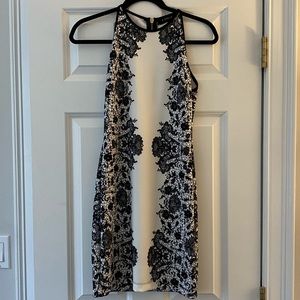 Black and White Fitted Cocktail Dress. Fits Size XS/S. Gold Zipper Closure.
